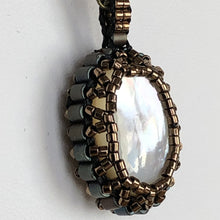 Load image into Gallery viewer, Mother of pearl cabochon framed by fine metallic bronze micro-beading