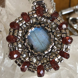 Fine beaded mandala style charm pendant with labradorite centerpiece surrounded by freshwater pearl and garnet gemstone