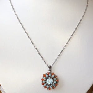 Beaded charm pendant with blue topaz center piece and mandala of larimar and carnelian with metallic steel micro-beading.