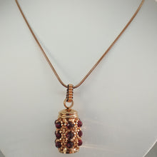 Load image into Gallery viewer, Facetted garnet and fine metallic glass bead encrusted tiny urn pendant. Rose-gold. Lock of hair keepsake. Cremation jewellery.