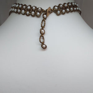 Showing the back adjustable toggle of boho style multi-strand necklace with natural freshwater pearl and intricately woven metallic glass micro-beads and Swarovski drops.