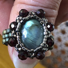 Load image into Gallery viewer, Beaded ring with labradorite centerpiece surrounded by facetted garnet and fine micro-beading. Mat teal beaded band.