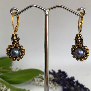 Beaded pearl earrings with bronze-tone glass beads circling a blue freshwater pearl on lever-back steel wires