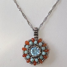 Load image into Gallery viewer, Beaded charm pendant with blue topaz center piece and mandala of larimar and carnelian with metallic steel micro-beading.