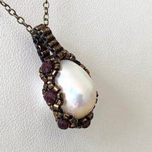 Load image into Gallery viewer, Large baroque freshwater pearl surrounded by metallic micro-beading with facetted garnet, suspended on trace chain.