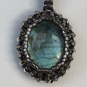 Labradorite cabochon pendant framed by fine metallic steel micro-beading