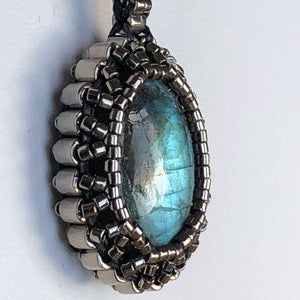 Labradorite cabochon pendant framed by fine metallic steel micro-beading