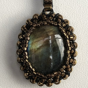 Golden flash labradorite cabochon pendant framed by fine beading of metallic glass micro beads